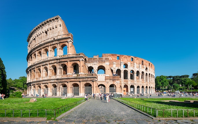 Colosseum in Rome with tourists exploring the ancient amphitheater.