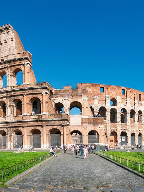 Colosseum in Rome with tourists exploring the ancient amphitheater.