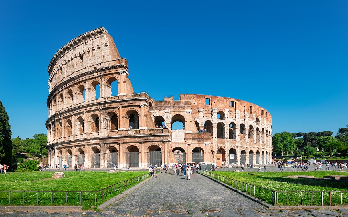 Colosseum in Rome with tourists exploring the ancient amphitheater.