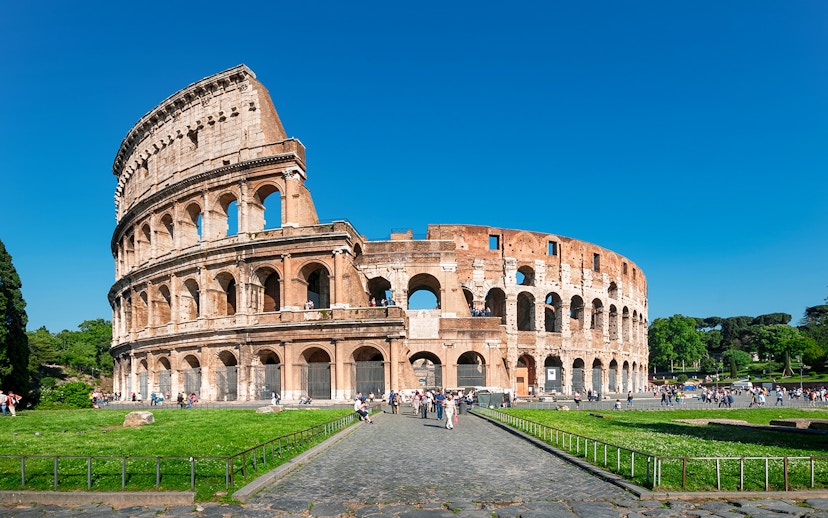 Colosseum in Rome with tourists exploring the ancient amphitheater.