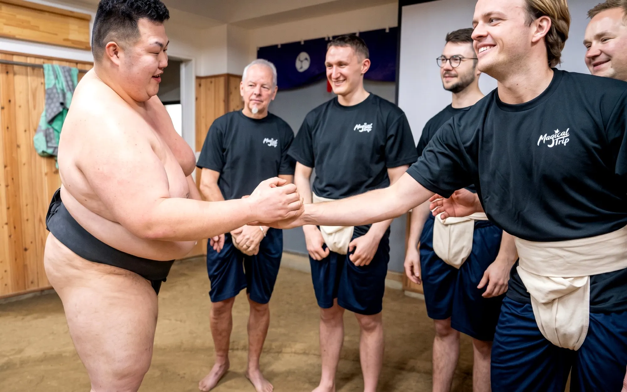 Sumo wrestler greeting tourists during an authentic sumo experience in Tokyo.