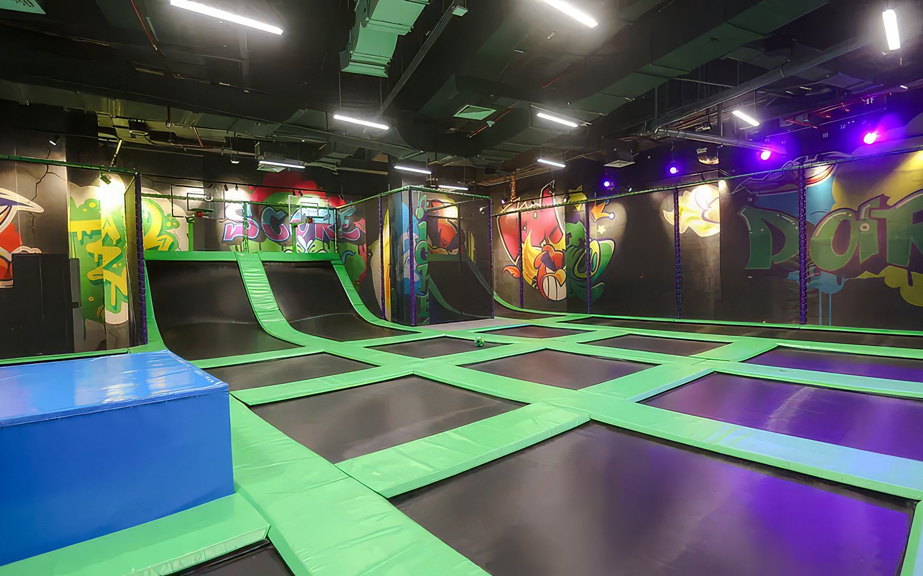 Indoor trampoline area at Angry Birds World Theme Park with colorful graffiti walls.
