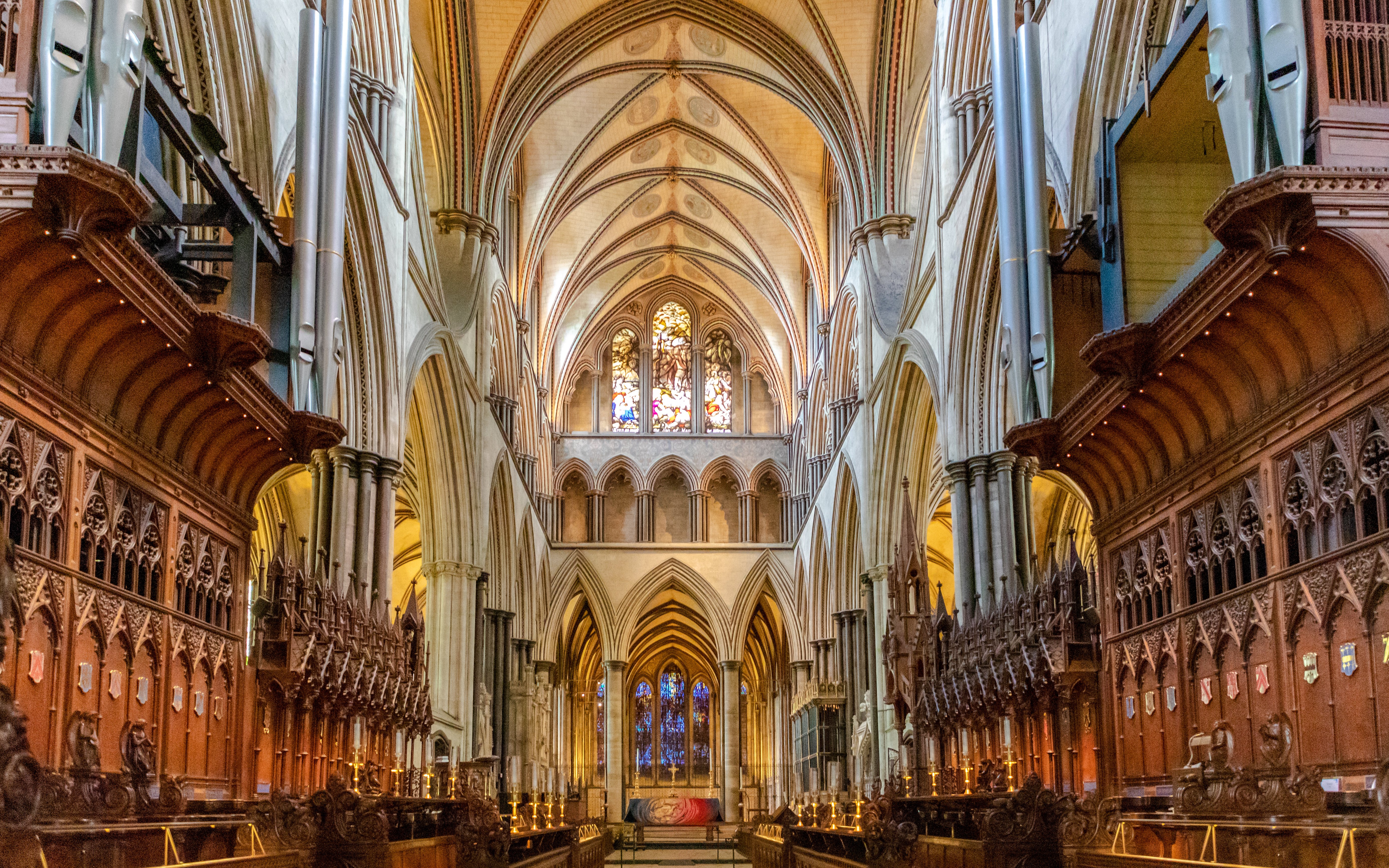 Salisbury Cathedral interior with vaulted ceilings and stained glass windows.
