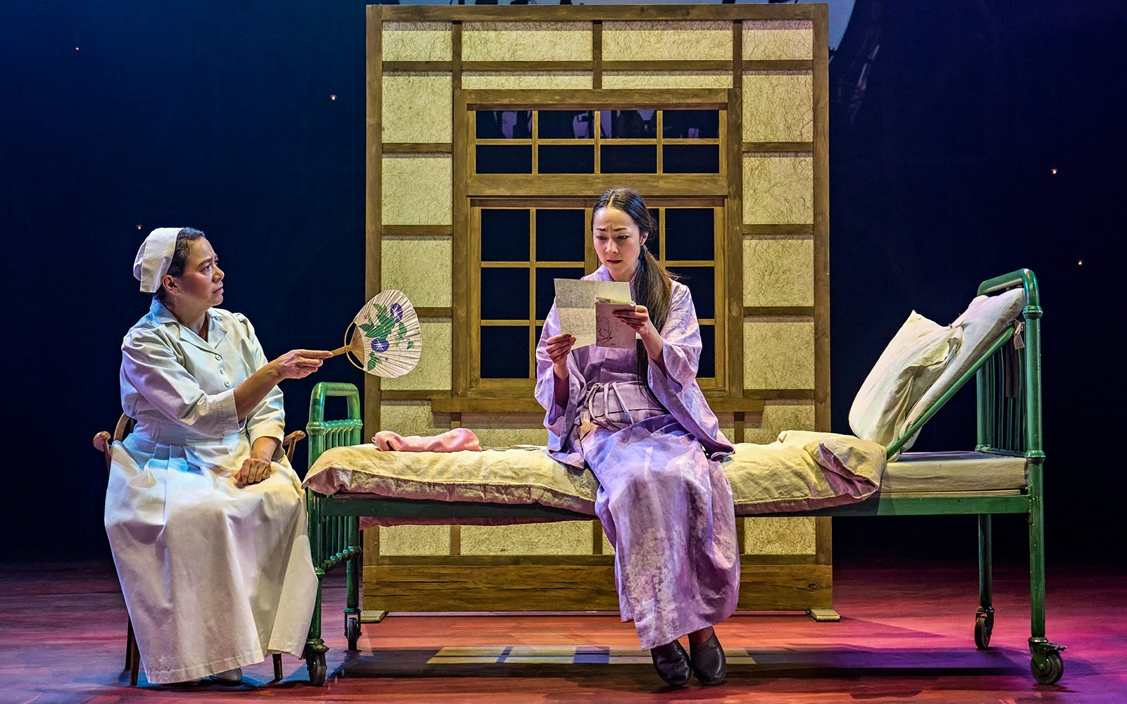 Stage scene from My Neighbour Totoro with two actors, one reading a letter.