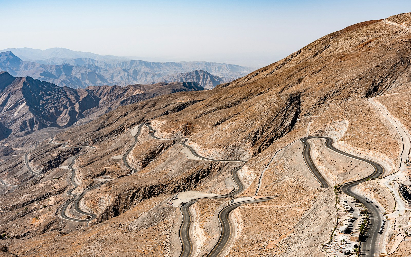 Winding road leading to the summit of Jebel Jais, Ras Al Khaimah, with mountain landscape in view.