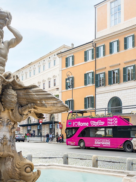 Triton Fountain with I Love Rome hop-on hop-off tour bus in Rome, Italy.