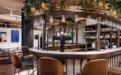 Bar area in Aspire Lounge at Copenhagen Kastrup Airport Terminal 2 with seating and drink options.