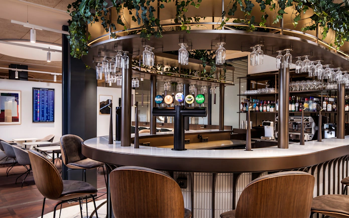 Bar area in Aspire Lounge at Copenhagen Kastrup Airport Terminal 2 with seating and drink options.