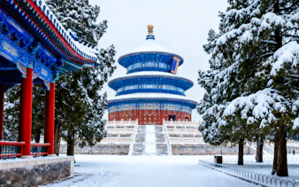 Temple of Heaven in Beijing covered in snow, showcasing traditional Chinese architecture.
