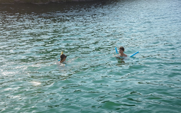 Tourists swimming with pool noodles during Arraial do Cabo Full Day Tour.