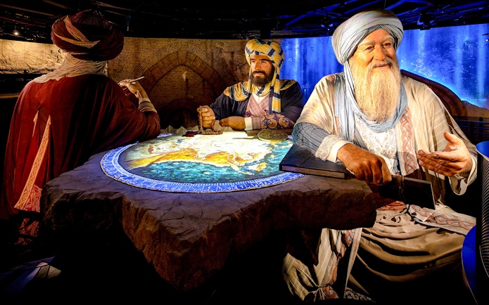 Historical figures discussing a map at Expo City Dubai exhibit.