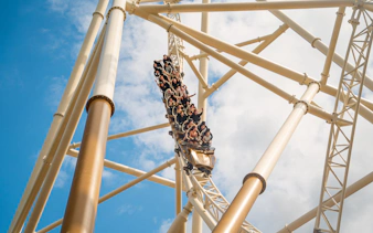 Roller coaster descending at Thorpe Park against blue sky.