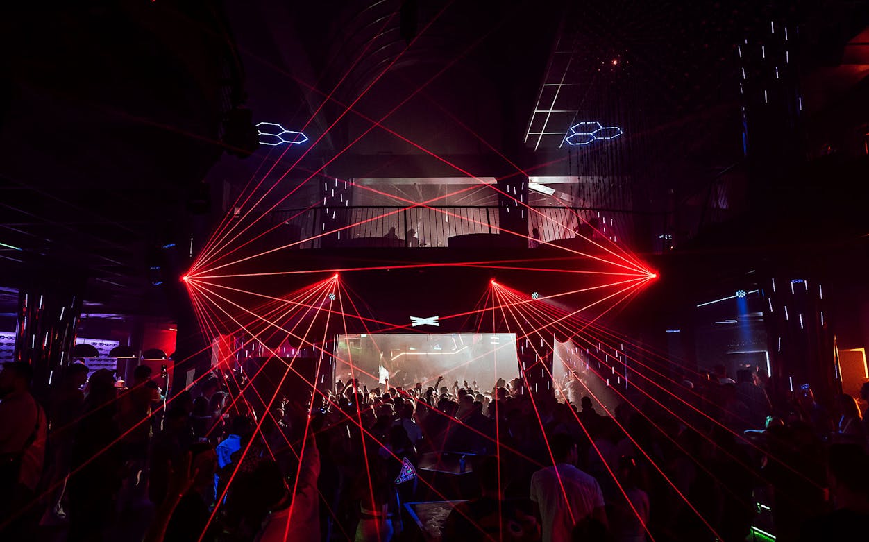 Nightclub with red laser lights and crowd at Eden on Saturdays event.