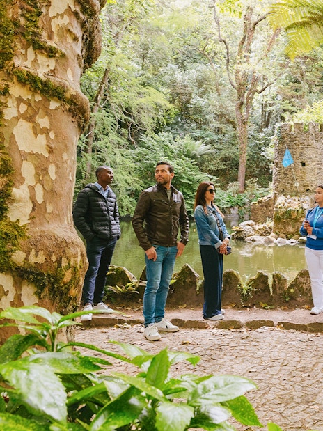 Group of tourists exploring gardens during Pena Palace guided tour in Sintra, Portugal.