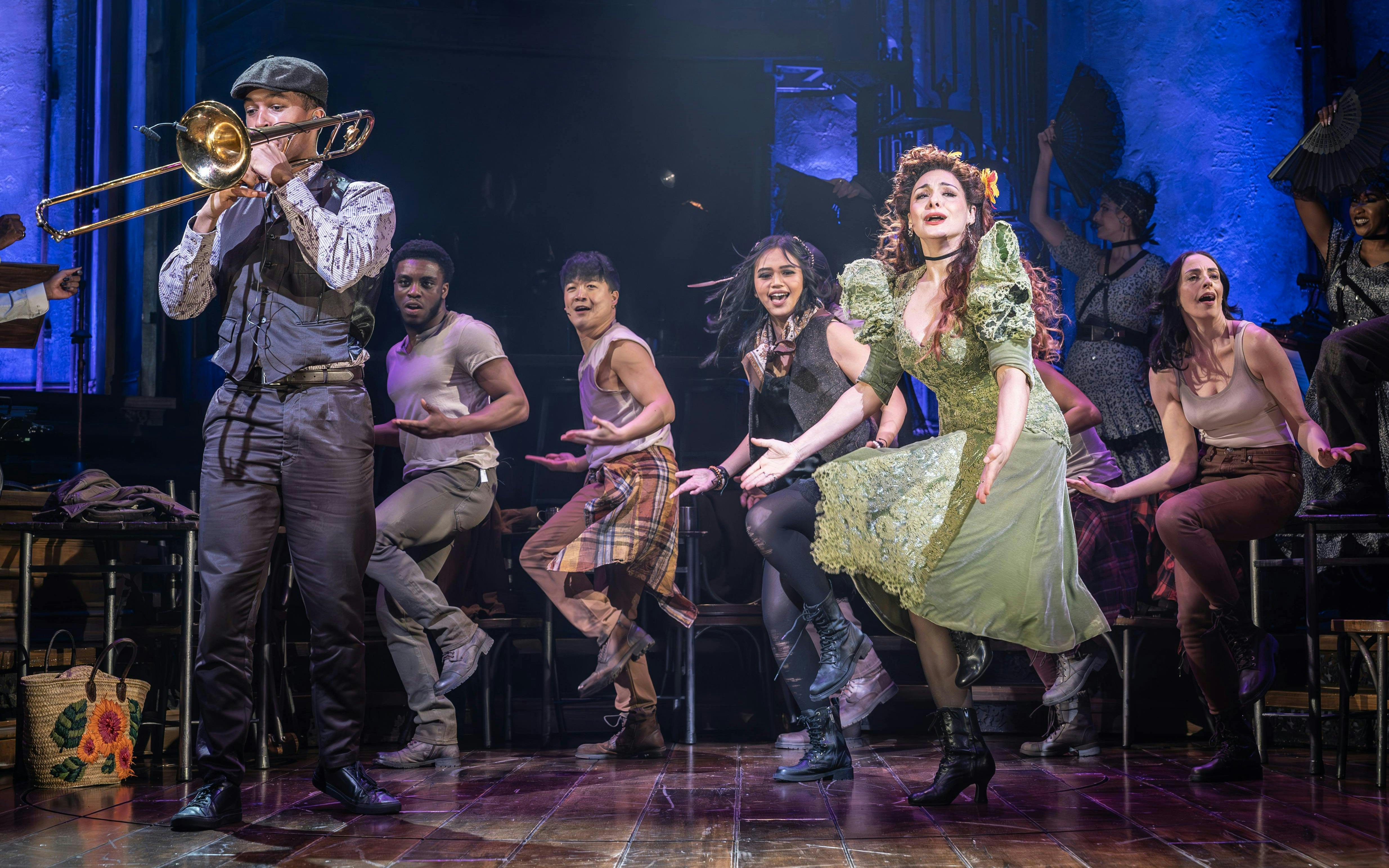 Stage performance of Hadestown in West End with actors singing and dancing.