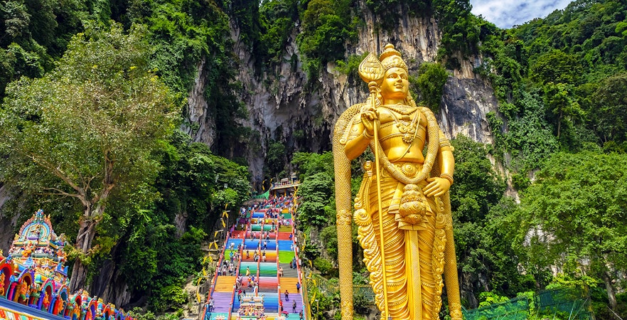 Golden Lord Murugan statue and colorful steps at Batu Caves, Malaysia.
