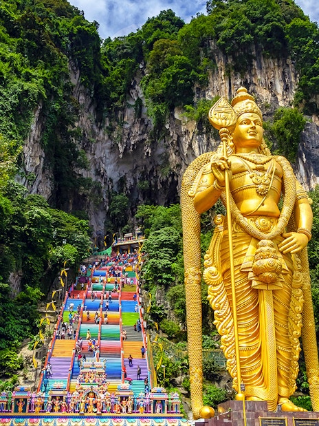 Golden Lord Murugan statue and colorful steps at Batu Caves, Malaysia.