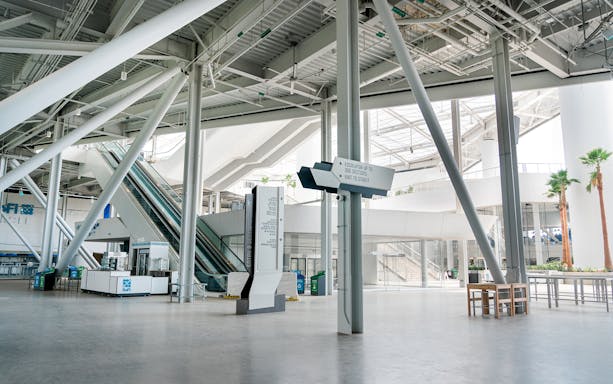 SoFi Stadium interior with escalators and directional signs.