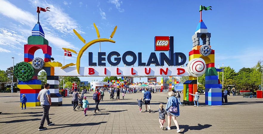 Entrance to LEGOLAND Billund with colorful LEGO structures and visitors.