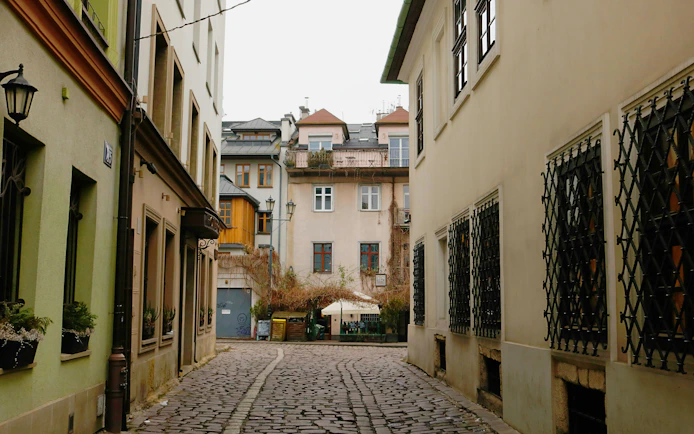 Krakow Kazimierz district cobblestone street with historic buildings on Schindler’s Story tour.