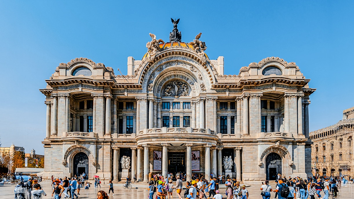 Tourists and visitors outside the Palace of Fine Arts, Mexico City, admiring the iconic architecture.