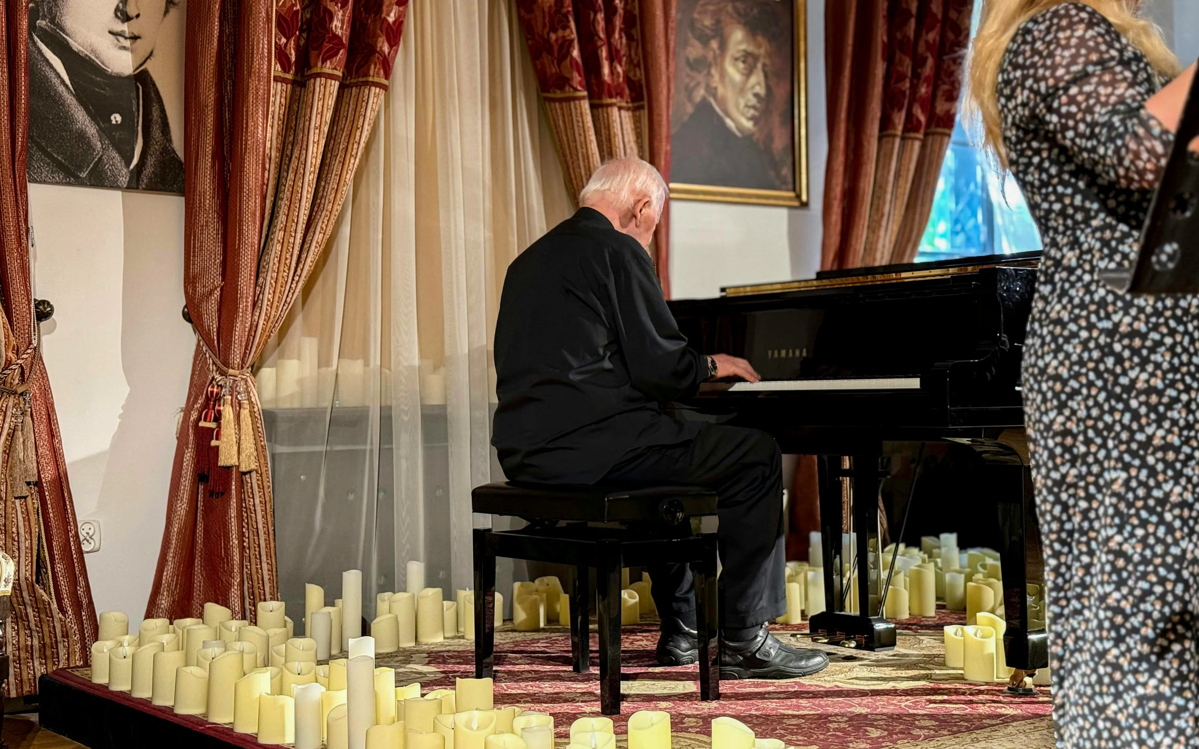 Pianist performing Jewish Klezmer music at a Krakow concert surrounded by candles.