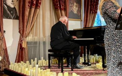Pianist performing Jewish Klezmer music at a Krakow concert surrounded by candles.