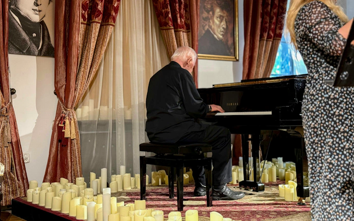 Pianist performing Jewish Klezmer music at a Krakow concert surrounded by candles.