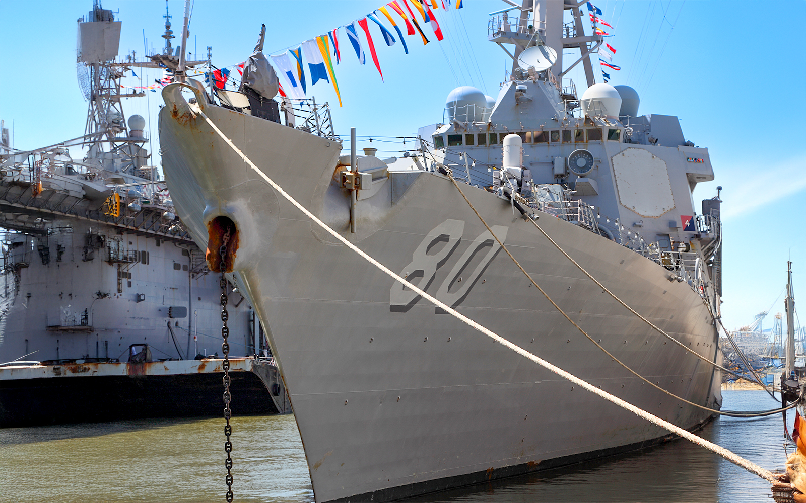 US Navy Destroyer docked in New York Harbor during Fleet Week with city skyline in background.