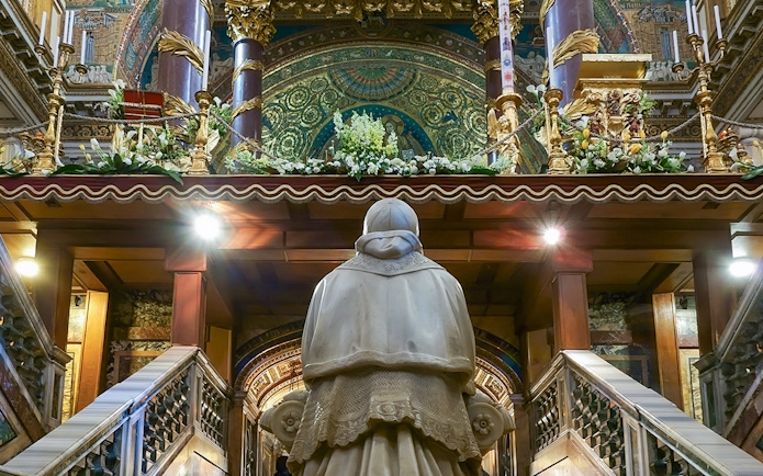 Statue in Santa Maria Maggiore's Crypt of the Nativity, Rome, with ornate altar above.