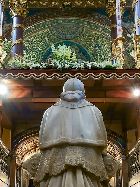 Statue in Santa Maria Maggiore's Crypt of the Nativity, Rome, with ornate altar above.