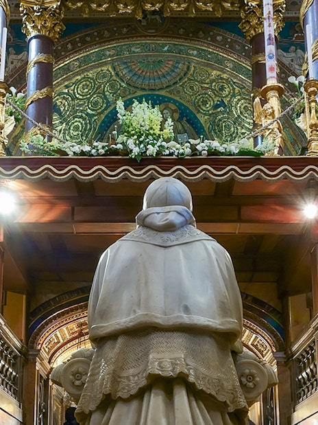 Statue in Santa Maria Maggiore's Crypt of the Nativity, Rome, with ornate altar above.