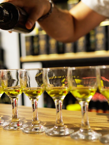 Olive oil being poured into tasting glasses during a Chianti experience.