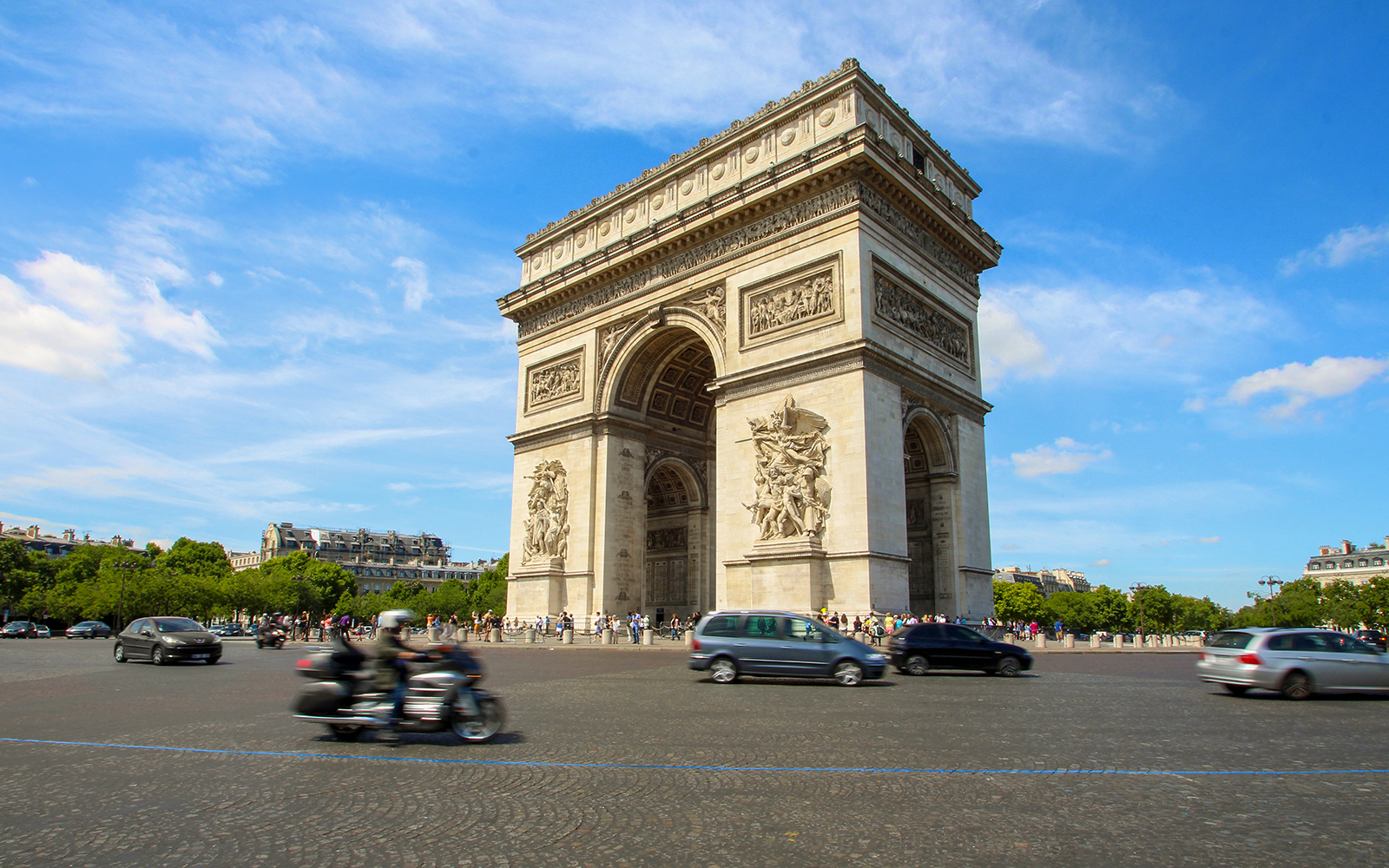 Turistas explorando o histórico Arco do Triunfo em Paris com um guia de áudio, proporcionando uma experiência única e informativa