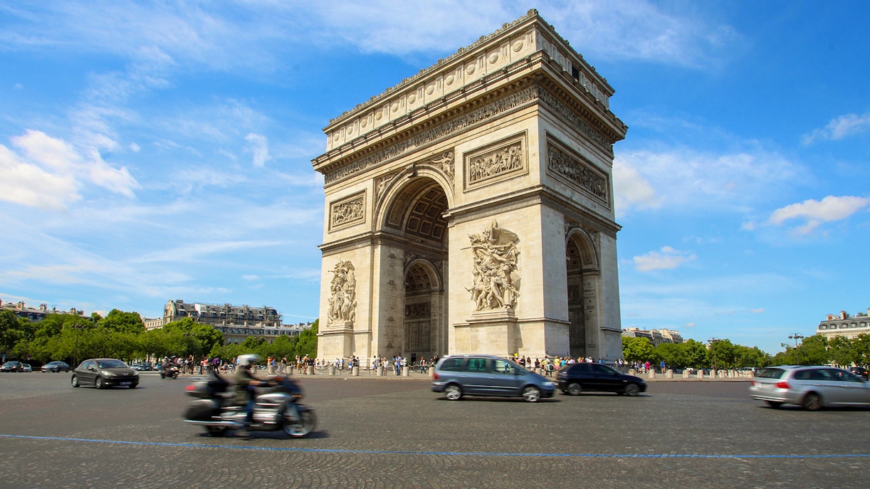Tourists with audio guides at the Arc de Triomphe, Paris, enjoying a historic exploration.