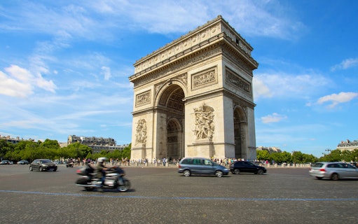 Tourists with audio guides at the Arc de Triomphe, Paris, enjoying a historic exploration.
