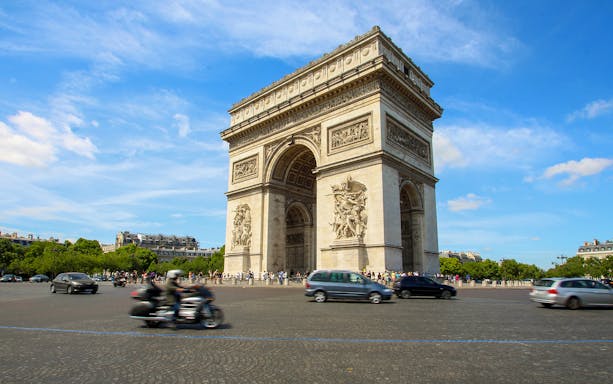 Tourists with audio guides at the Arc de Triomphe, Paris, enjoying a historic exploration.