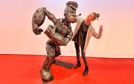 Steel figure of a cartoon character with a visitor at Gallery of Steel Figures, Prague.