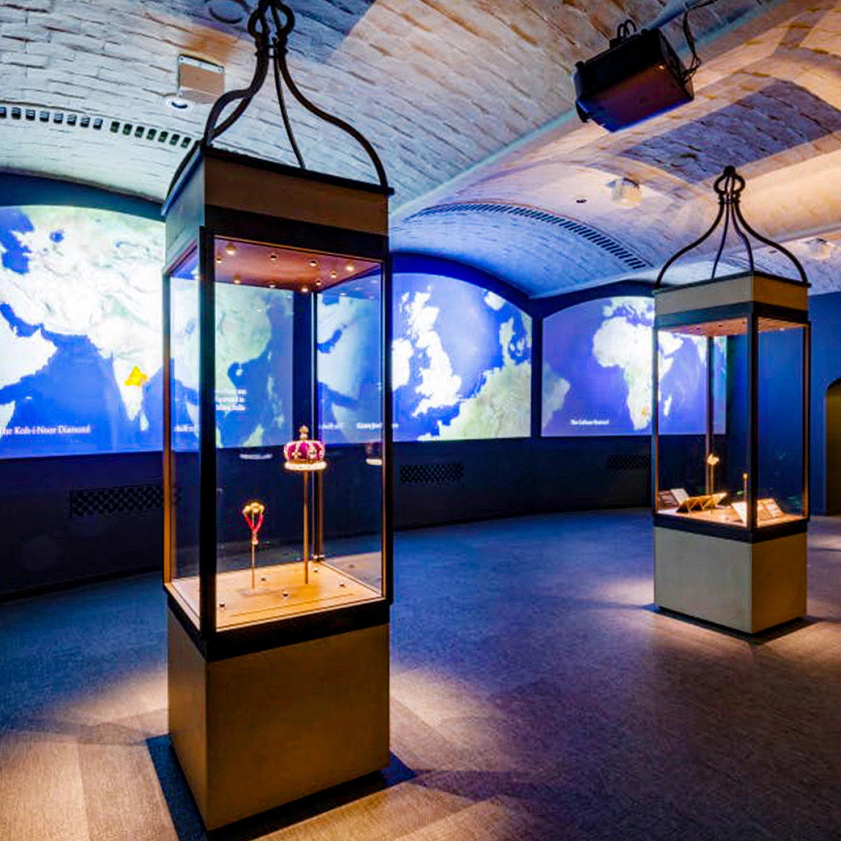 Crown jewels displayed in a glass case at the Tower of London exhibition hall.