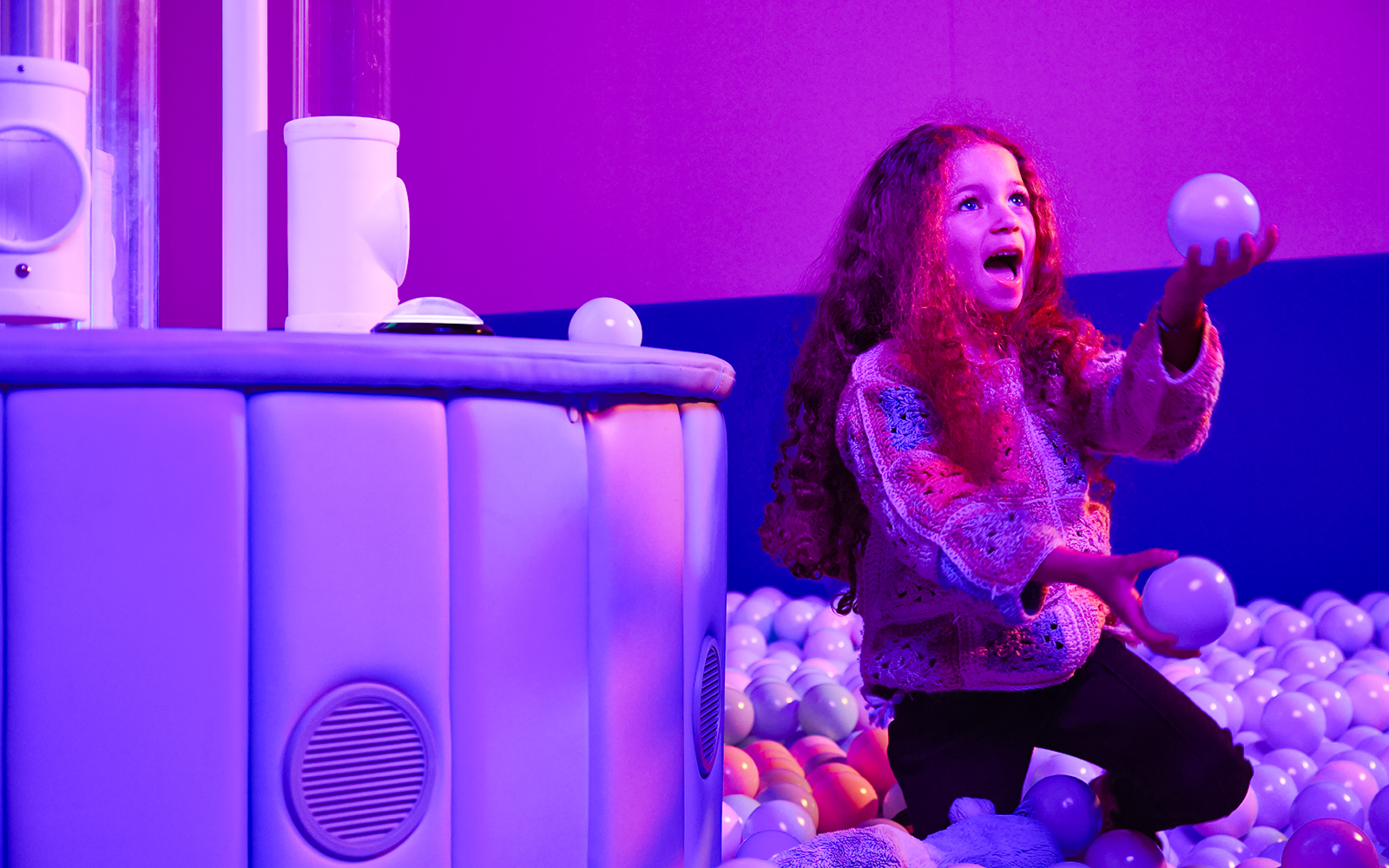 Child playing with balls at Bubble Planet exhibit, Washington DC.