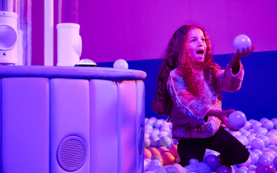 Child playing with balls at Bubble Planet exhibit, Washington DC.