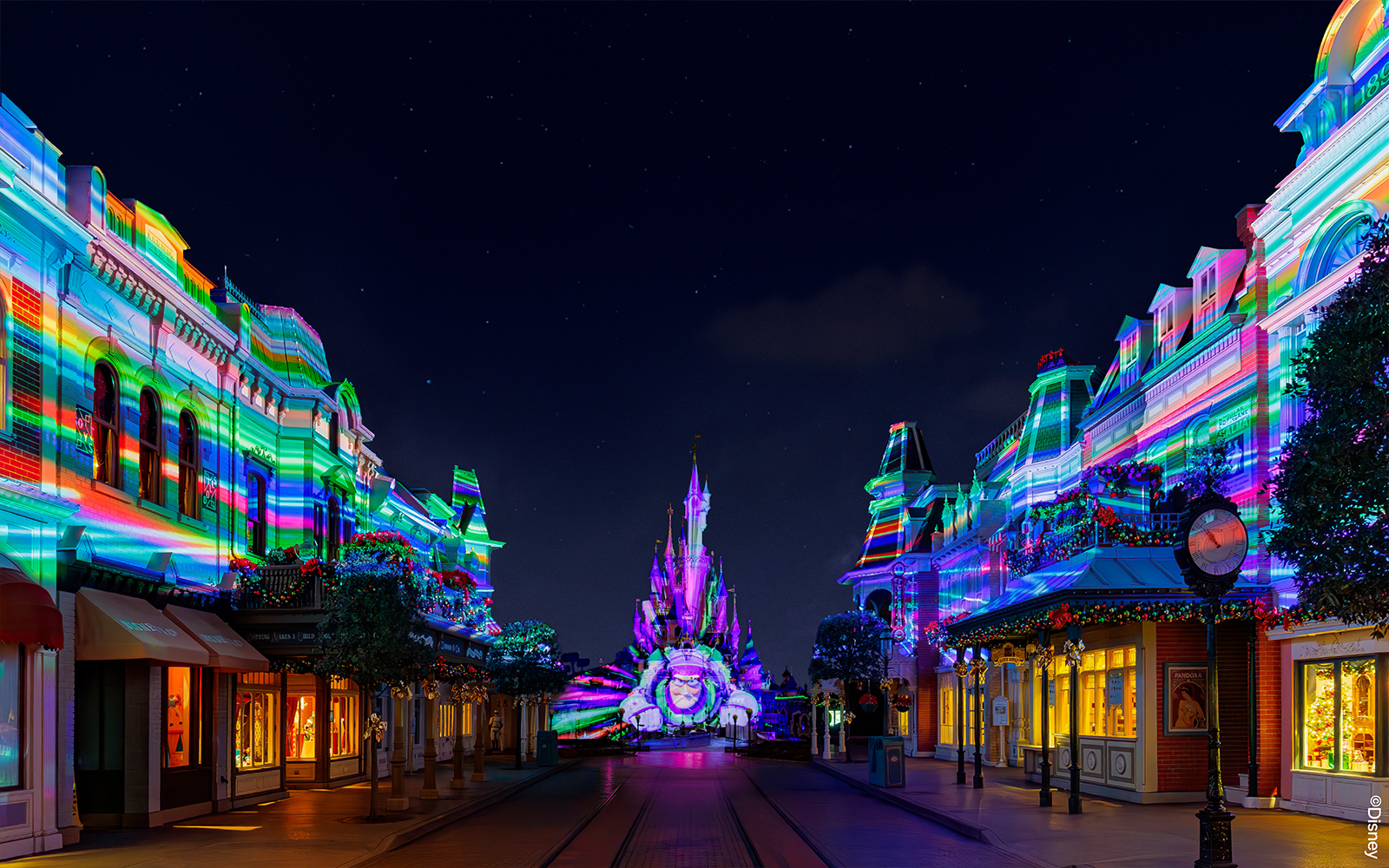 Disneyland Paris castle illuminated during night light show.