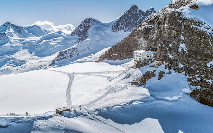 Jungfraujoch snowy landscape with mountain peaks and a building, seen on a day trip from Zürich.