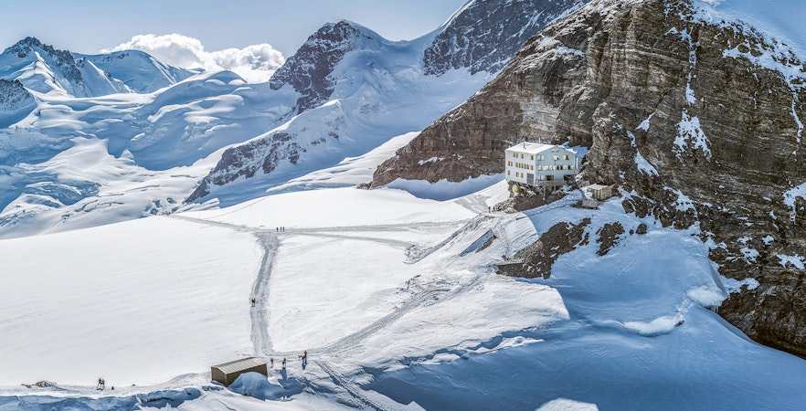 Jungfraujoch snowy landscape with mountain peaks and a building, seen on a day trip from Zürich.