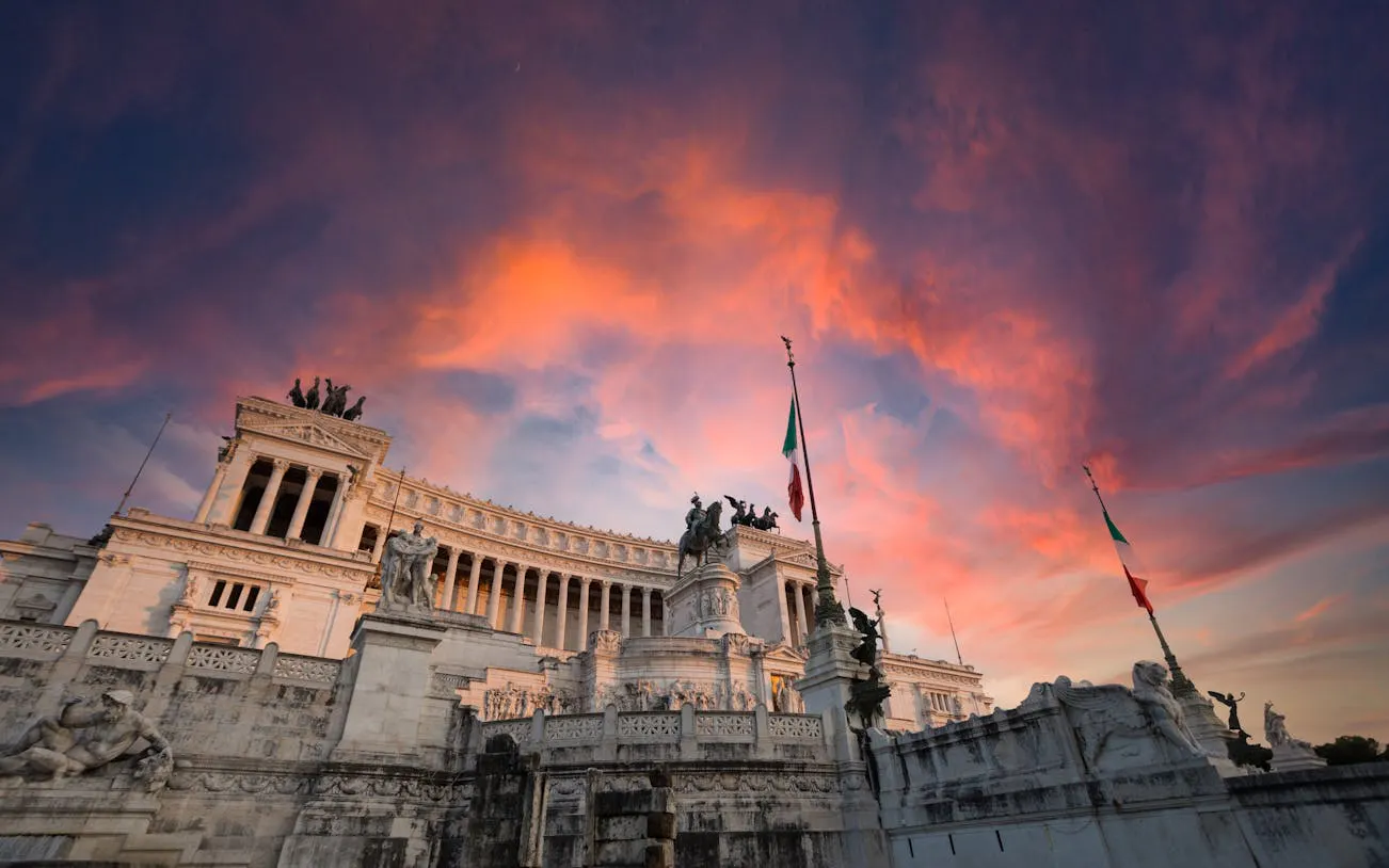 Vittoriano monument in Rome at sunset with vibrant sky.