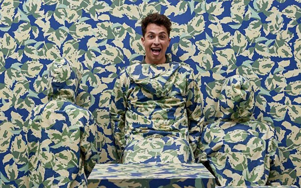 Person camouflaged against patterned wall at Paradox Museum Barcelona.