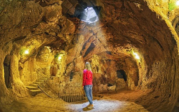 Visitor exploring an ancient cave in Ihlara Valley, Cappadocia.