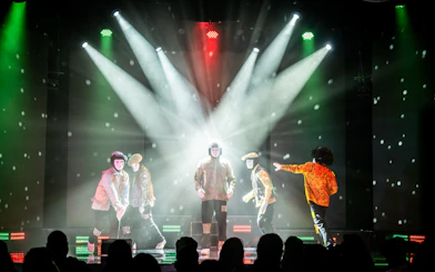 Jabbawockeez dancers performing on stage with dramatic lighting in Las Vegas show.