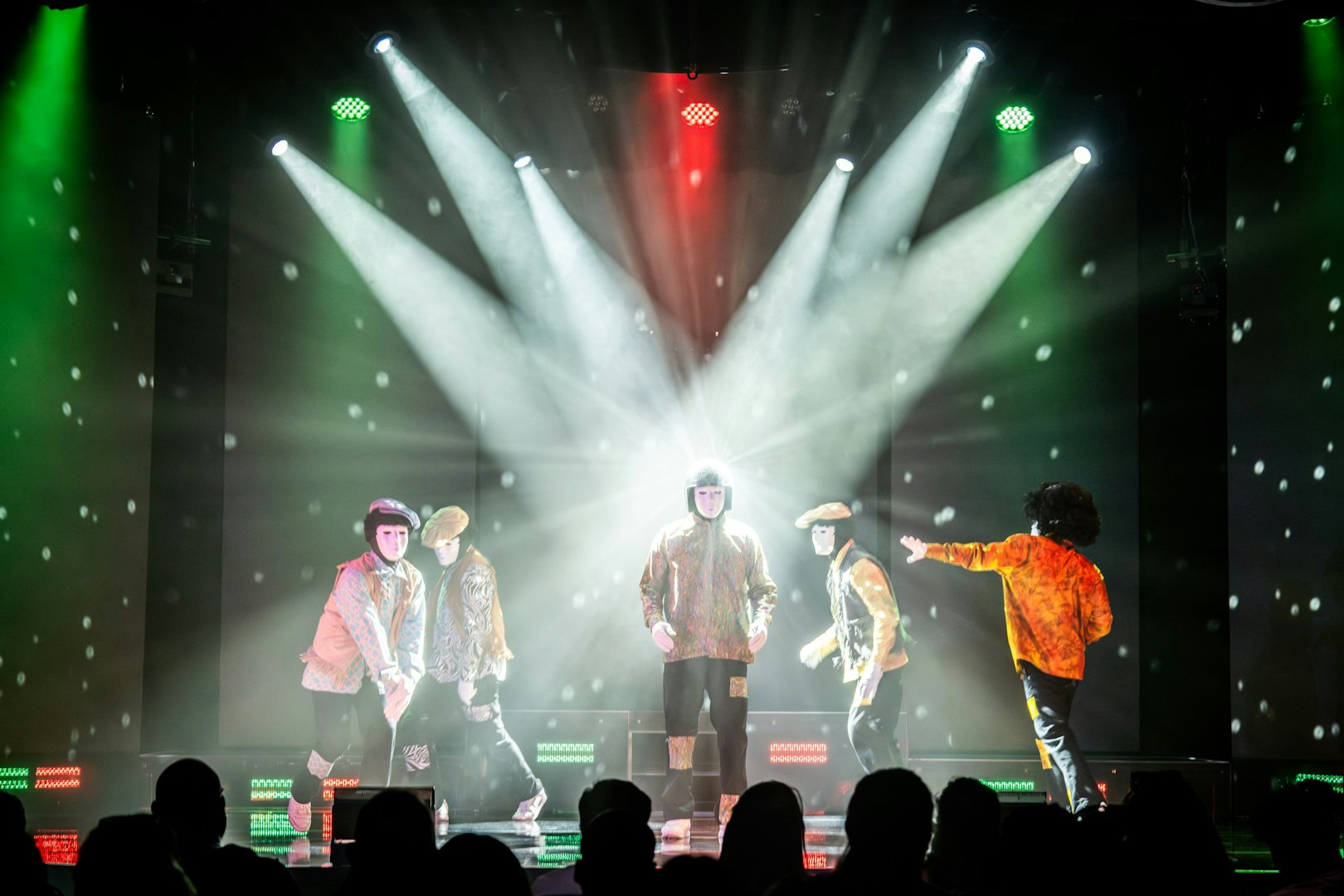 Jabbawockeez dancers performing on stage with dramatic lighting in Las Vegas show.