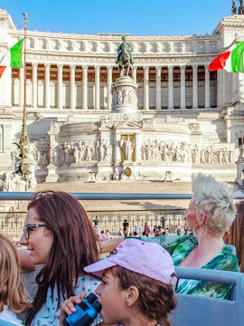 Tourists on Green Line Rome bus viewing Altare della Patria monument.